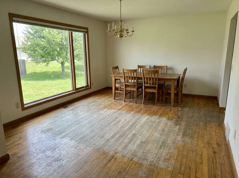 Dining room oak floor with a sun-faded, grayed area in front of a large window before refinishing